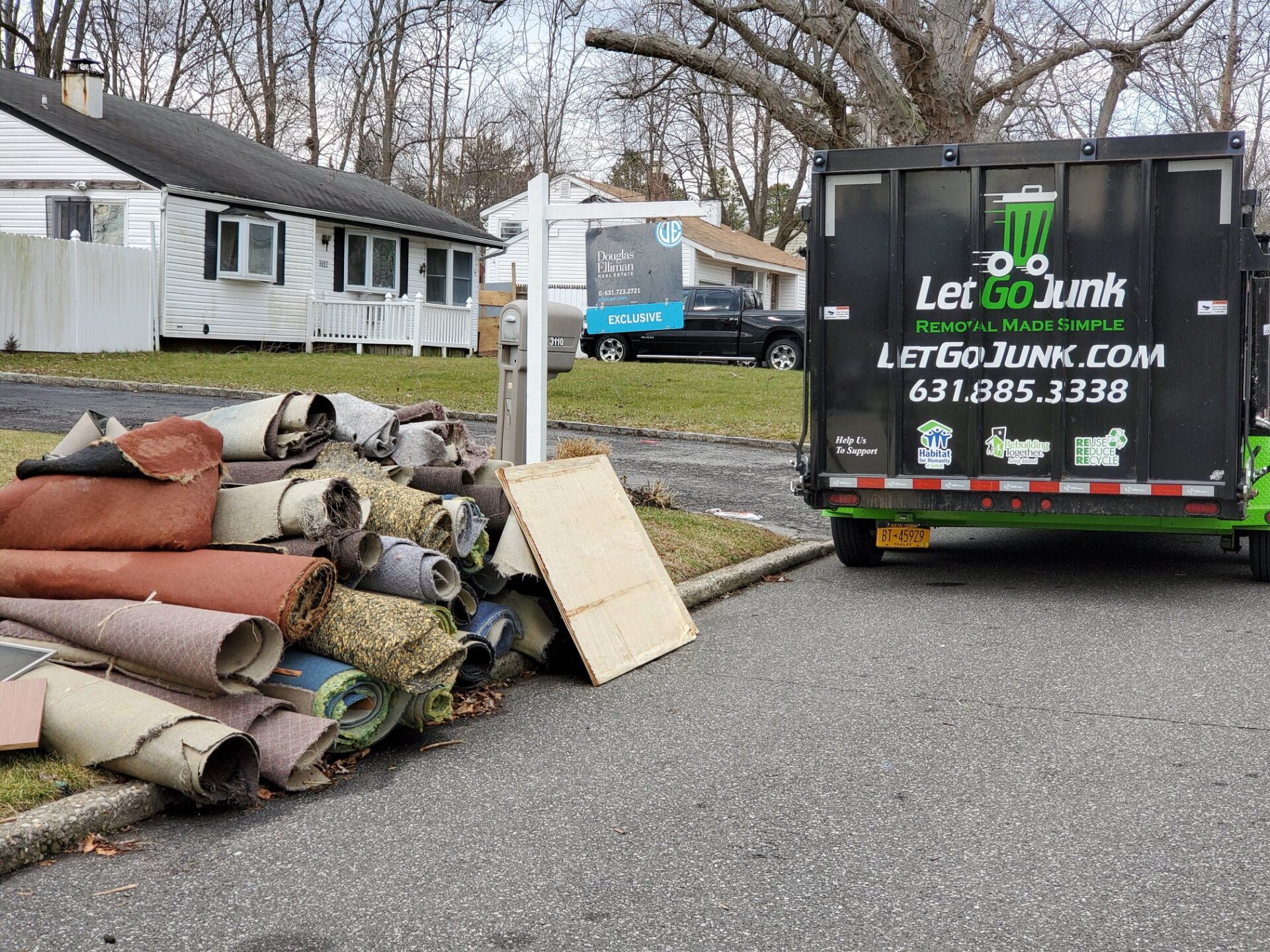 Carpets piled outside ready for Let Go Junk to load it into their dumpster